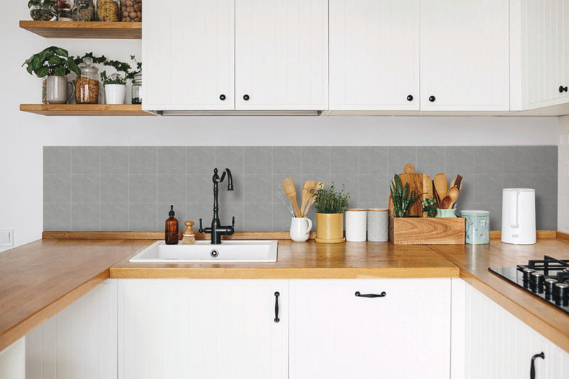 Kjøkken med lys grå selvklebende veggfliser i betonglook over benken